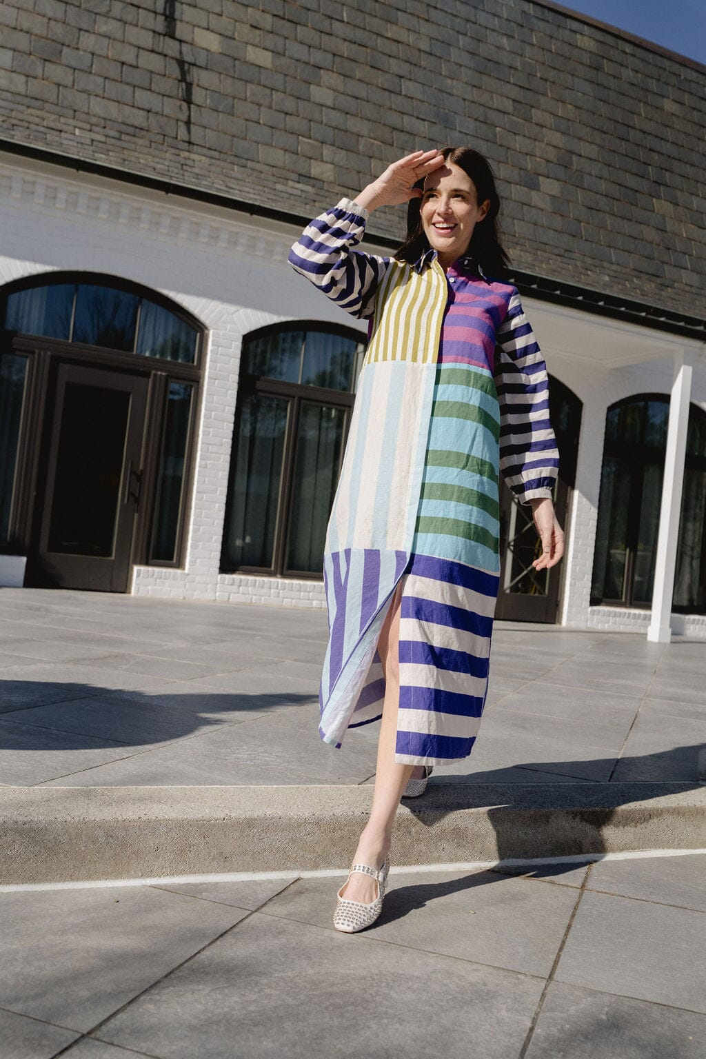 Linen beach maxi dress with vertical stripes, flowing in the breeze by the shoreline