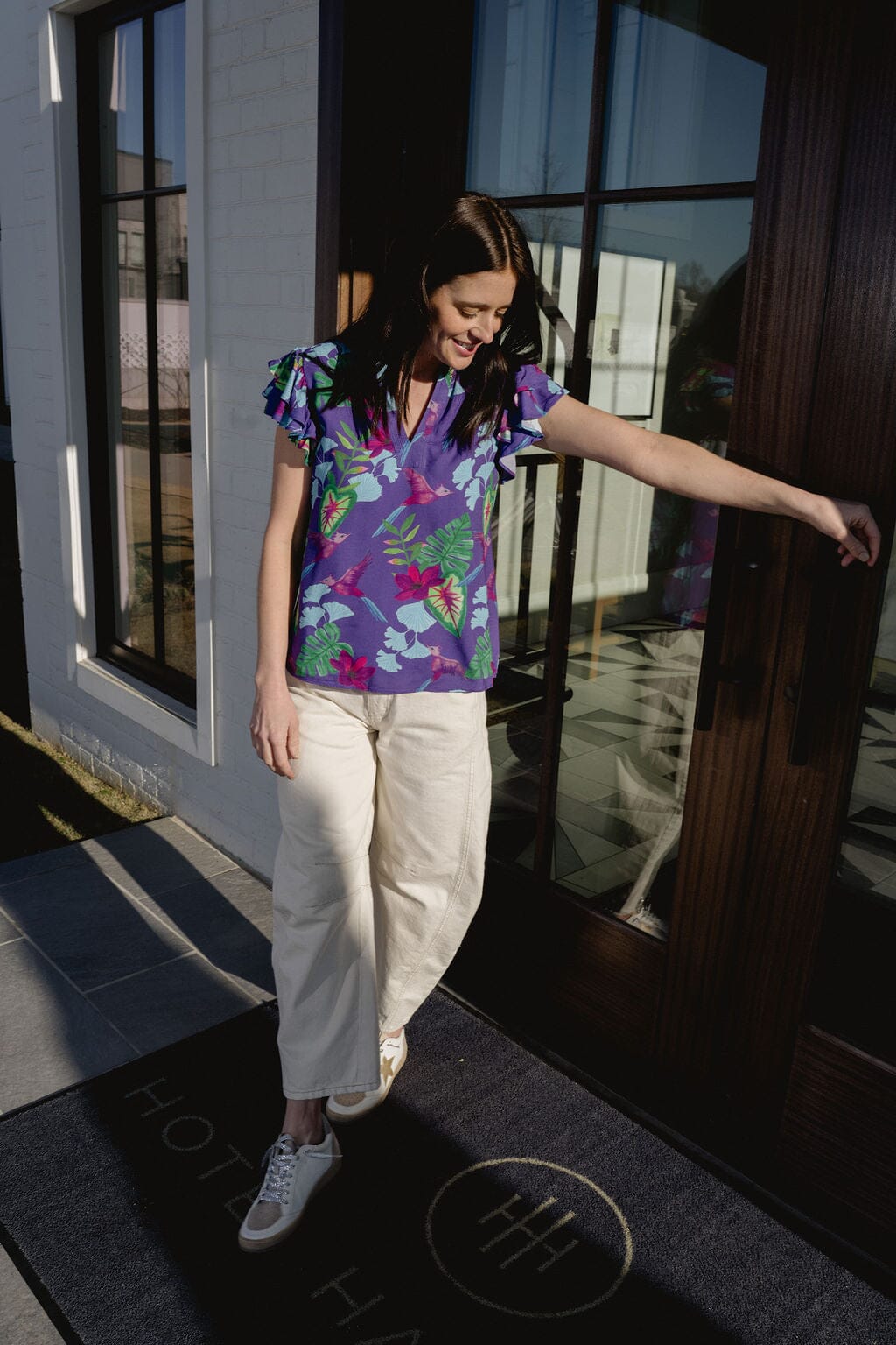 girl standing at resort in floral top