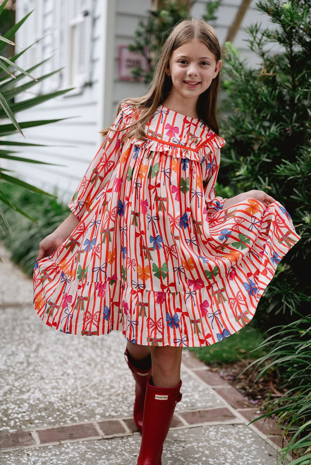 Girls twirling in Blair Holiday Dress-Briton Court with bows ans stripes
