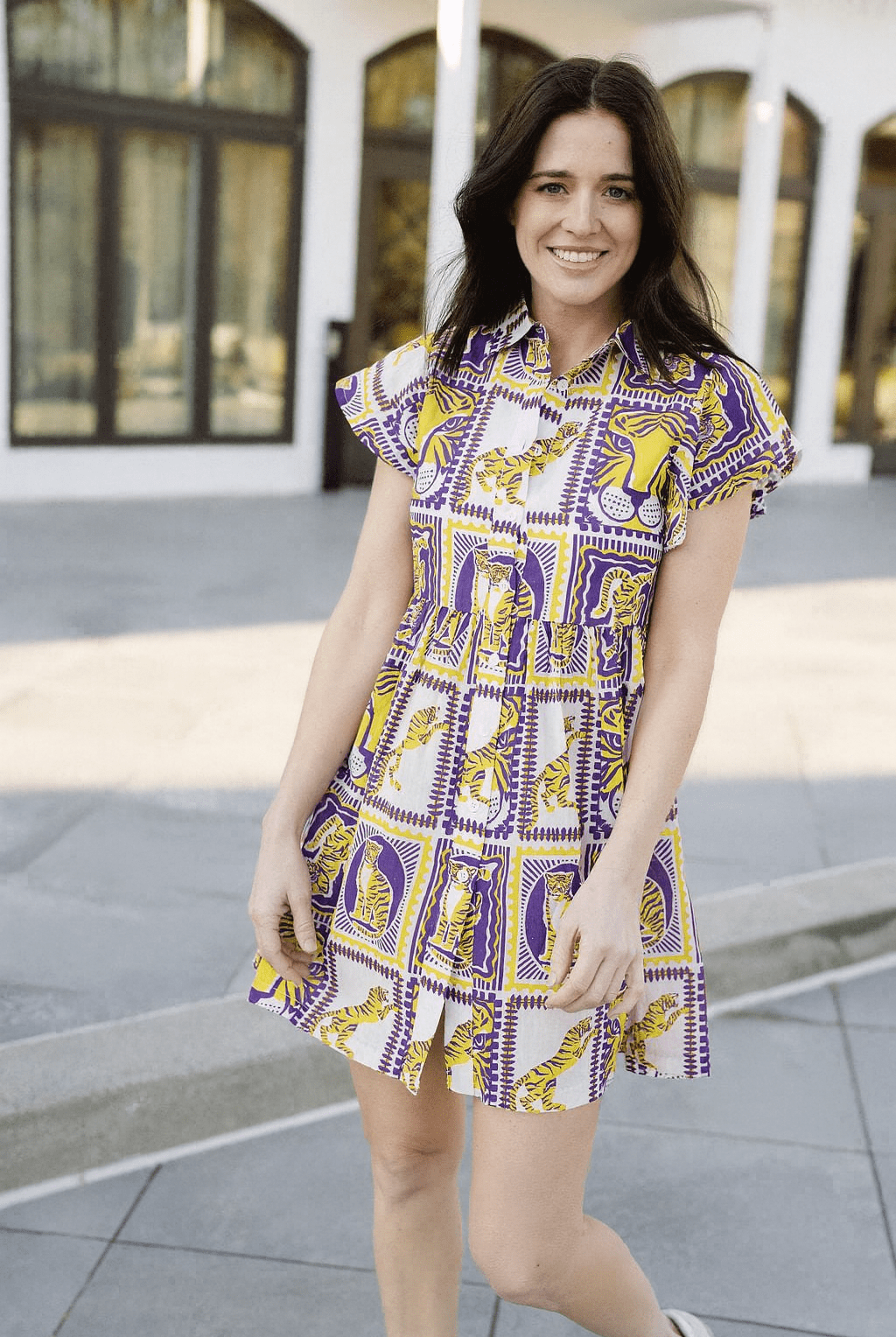 Woman wearing a patterned dress standing outdoors.