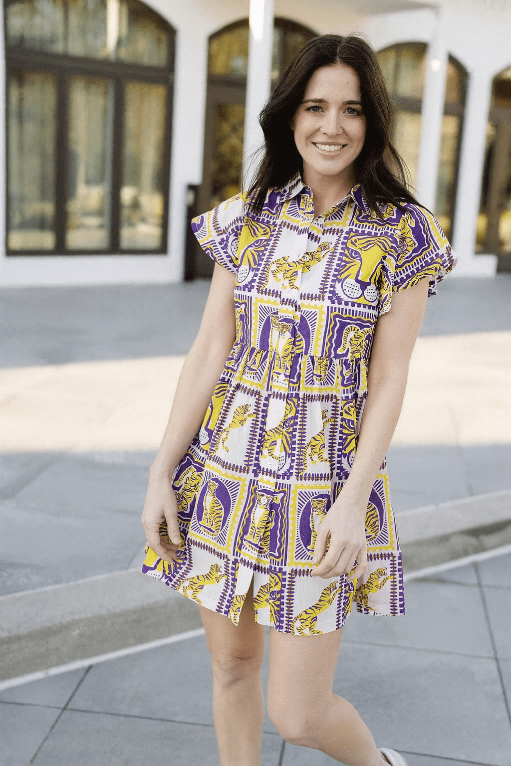 Woman wearing a patterned dress standing outdoors.