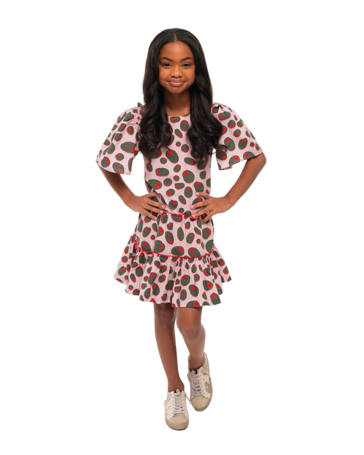 Girl smiling with her hands on her hips while wearing Ruby Olive Rose dress.