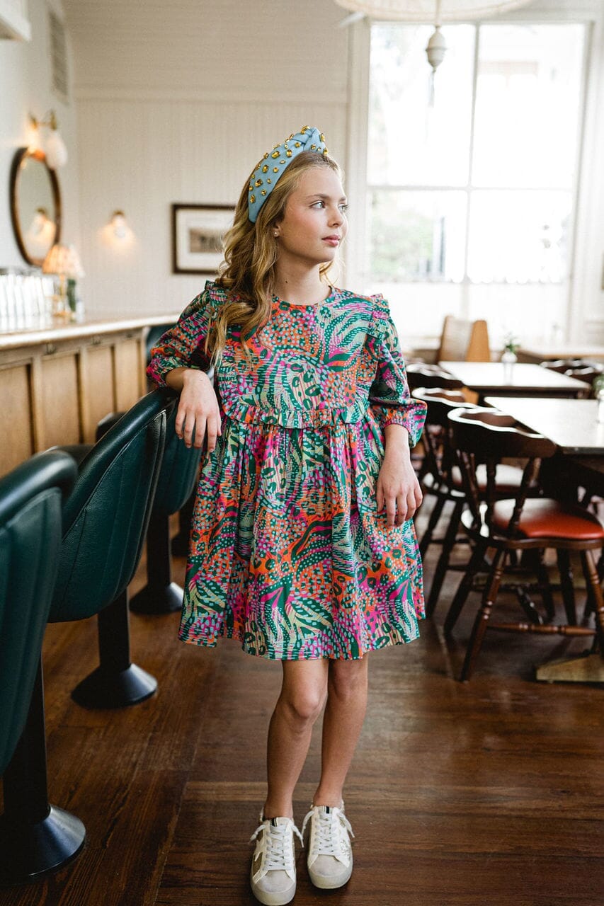 Girl looking away while wearing Willow Ruffle Bib dress.