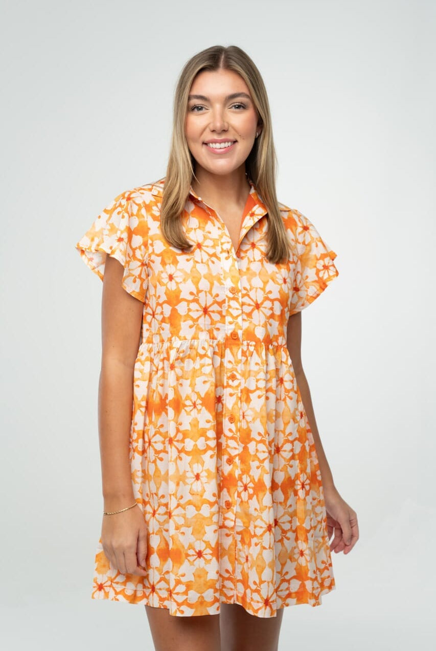 "Orange and white floral gameday babydoll dress with flutter sleeves and button front, styled for tailgate or team spirit."