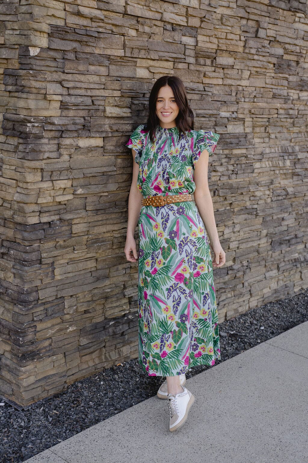model wearing floral skirt  standing in a blooming garden.