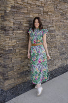 model wearing floral skirt  standing in a blooming garden.