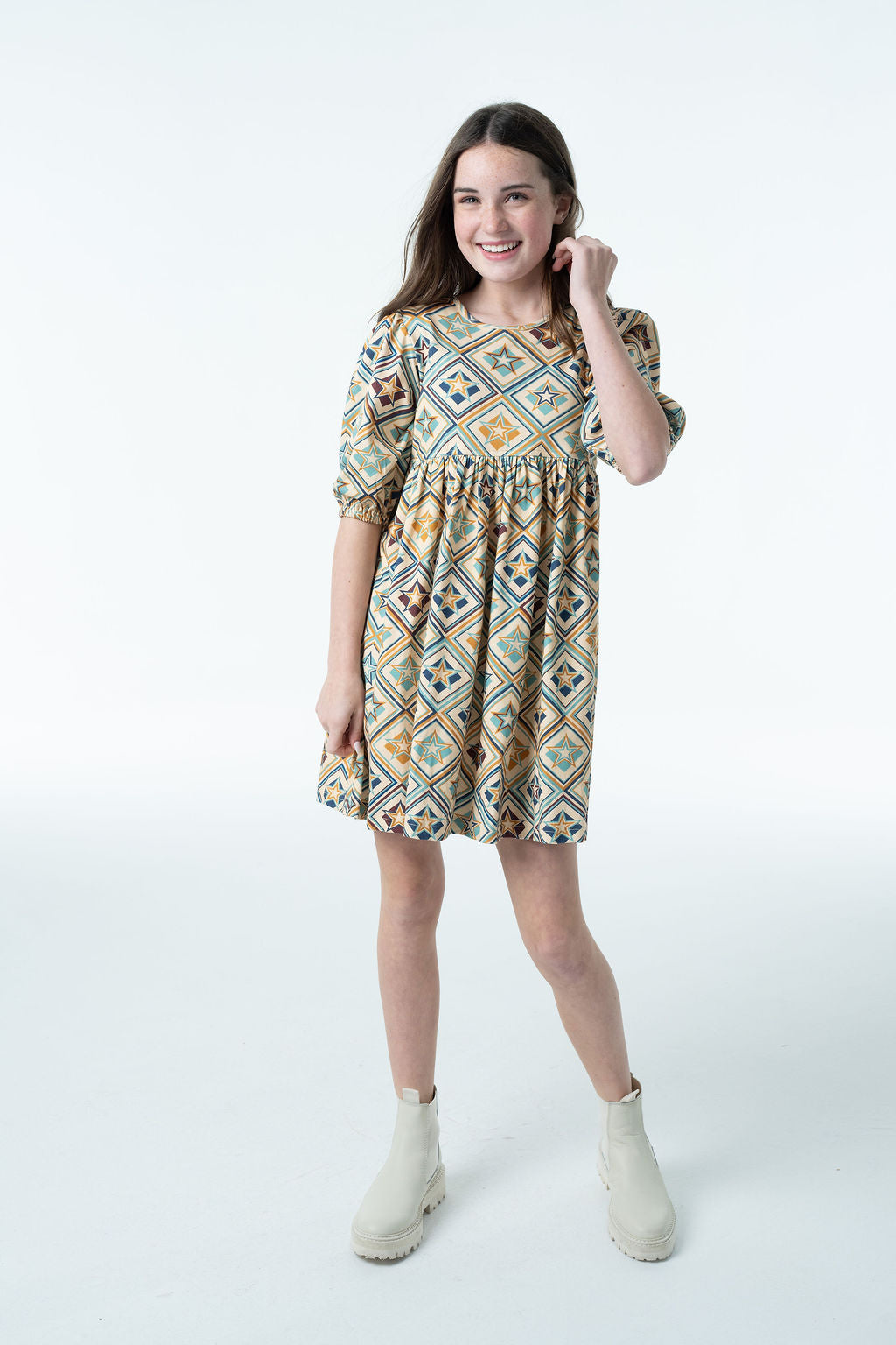 Girl wearing the Autumn Dress in a geometric star print with puff sleeves