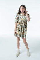 Girl wearing the Autumn Dress in a geometric star print with puff sleeves