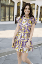 Woman wearing a patterned dress standing outdoors.