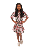 Girl smiling with her hands on her hips while wearing Ruby Olive Rose dress.