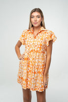Orange and white floral gameday babydoll dress with flutter sleeves and button front, styled for tailgate or team spirit.