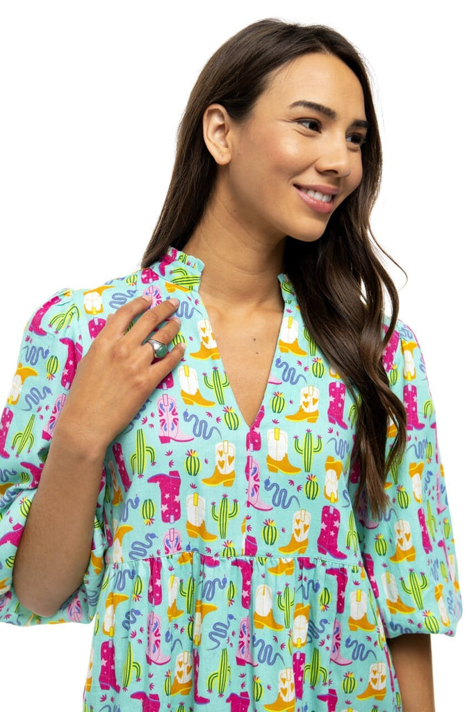 Close up picture of women smiling while showing the detail of Annie Bubble sleeve mini dress with cowboy boot designs