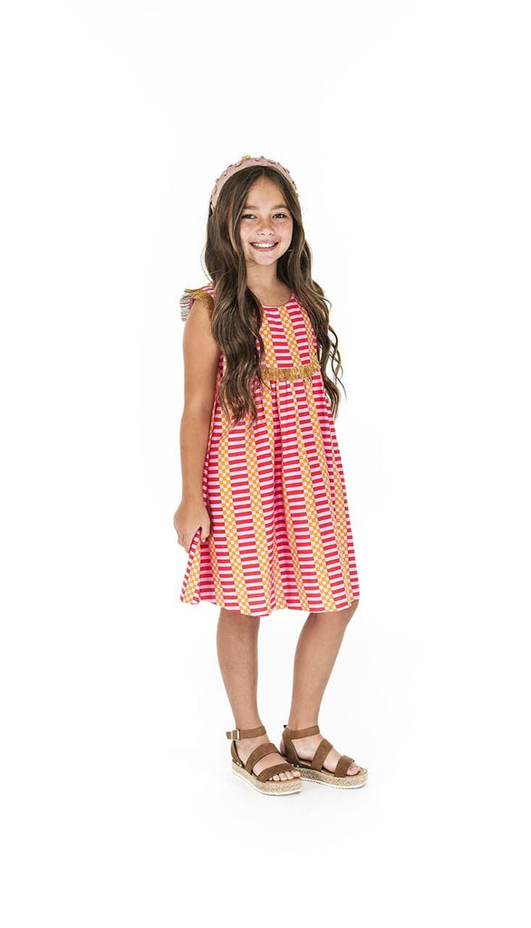 Girl smiling while turned to the side showing the Fringe Flamingo Pink dress